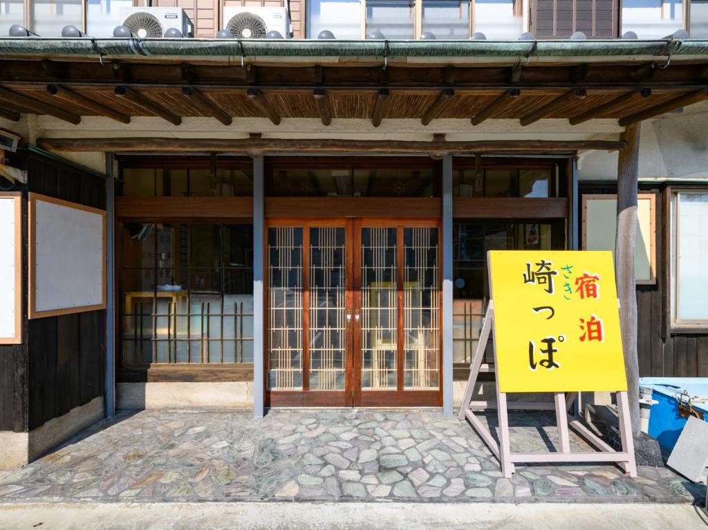 a building with a sign in front of it at Tabist Sakipo Minamichita in Morozaki
