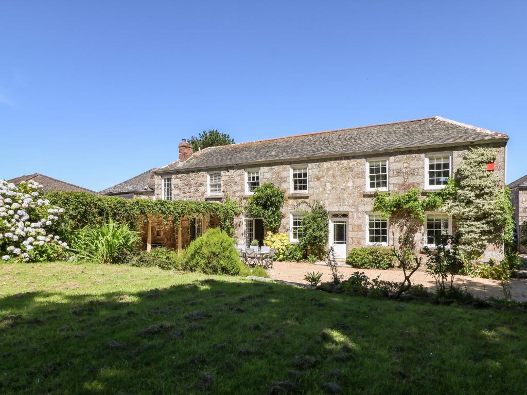 a large stone house with a large yard at Culdrose Manor in Helston
