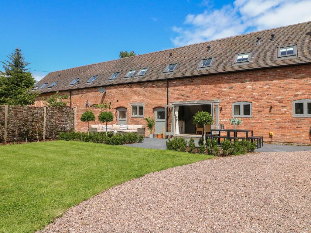 a brick building with a lawn in front of it at Upper Barn in Stafford