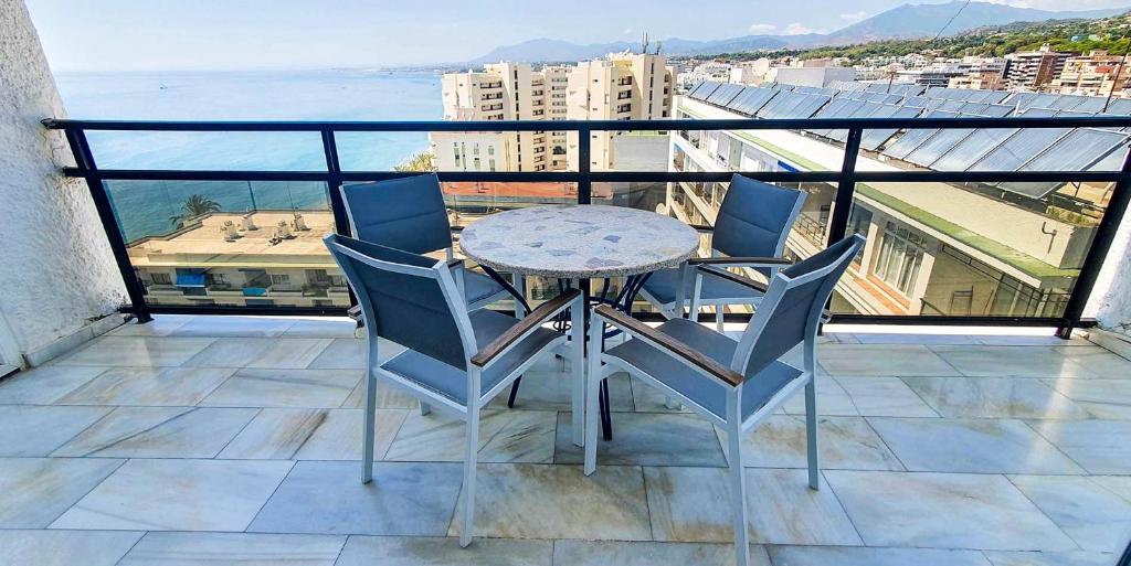 マルベーリャにあるSkol 708 Fantastic 2 Bedroom Apartment For Holiday Rentalsのテーブルと椅子、海の景色を望むバルコニー