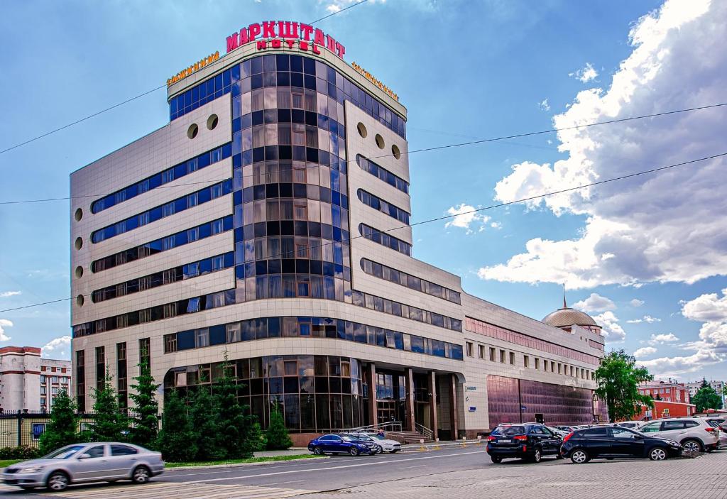 チェリャビンスクにあるMarkstadt Hotelの駐車場車を停めた大きな建物