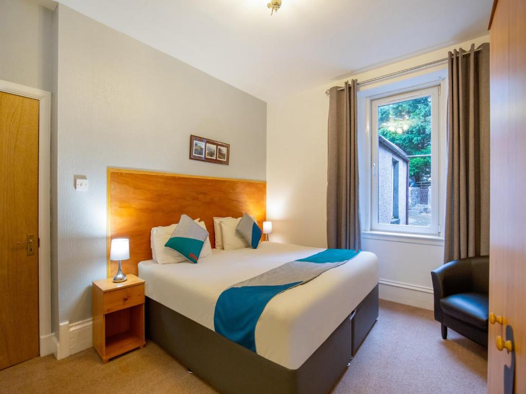 a hotel room with a large bed and a large window at OYO Eastbank Hotel in Rothes