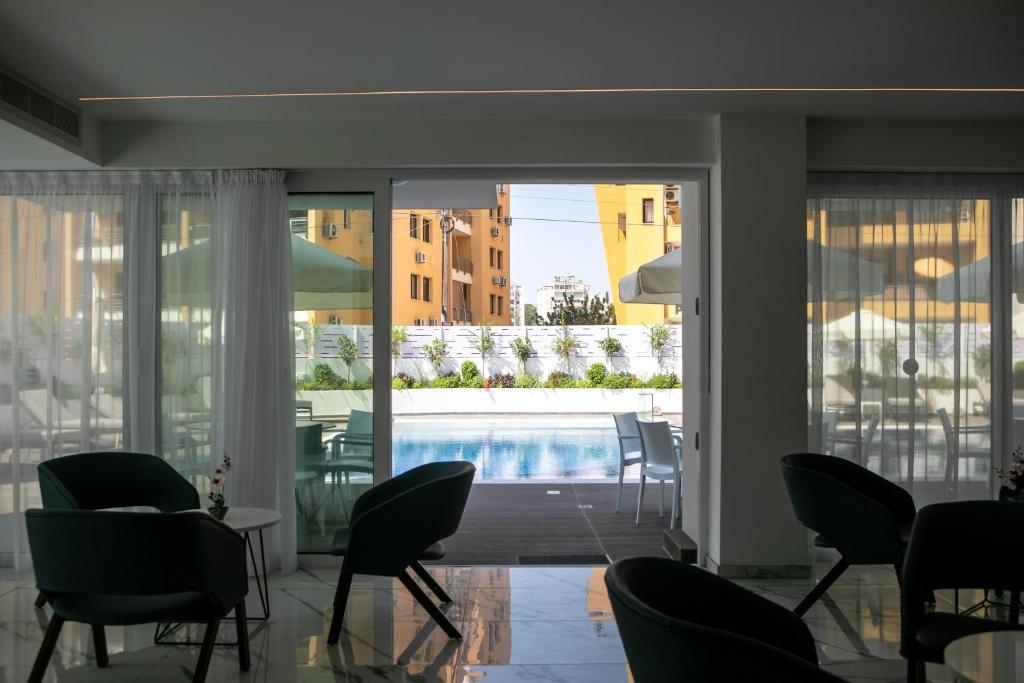 a living room with a pool seen through the sliding glass doors at Best Western Plus Larco Hotel in Larnaka