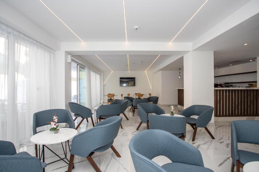 a waiting room with blue chairs and tables at Best Western Plus Larco Hotel in Larnaka