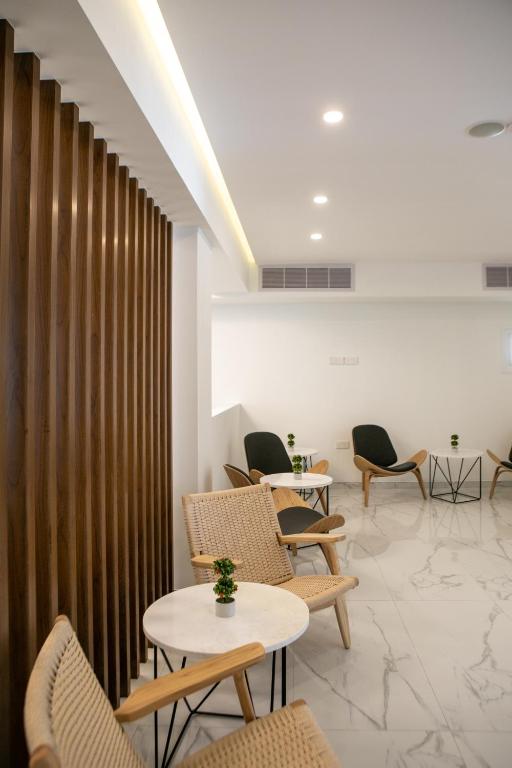 a waiting room with chairs and tables and a wall at Best Western Plus Larco Hotel in Larnaka