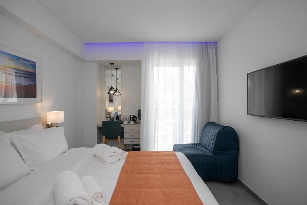a hotel room with a bed and a blue chair at Best Western Plus Larco Hotel in Larnaka