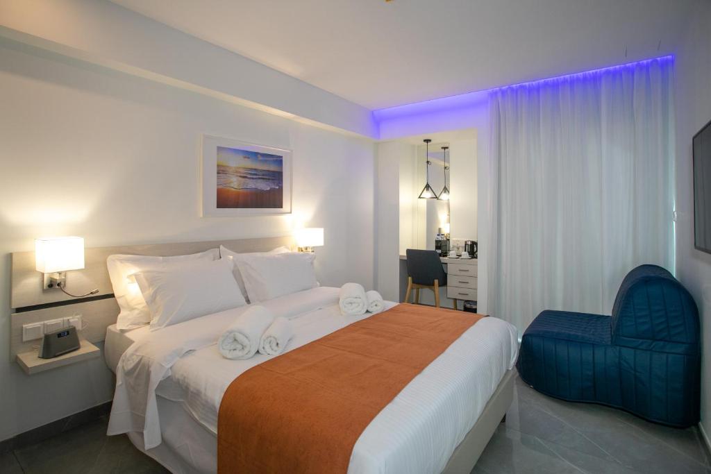 a bedroom with a large bed and a blue chair at Best Western Plus Larco Hotel in Larnaka