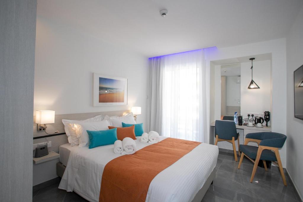 a bedroom with a bed with a desk and chairs at Best Western Plus Larco Hotel in Larnaka