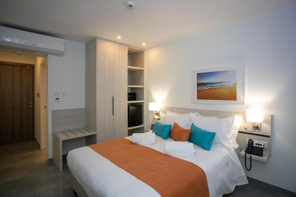 a bedroom with a large bed with blue and orange pillows at Best Western Plus Larco Hotel in Larnaka