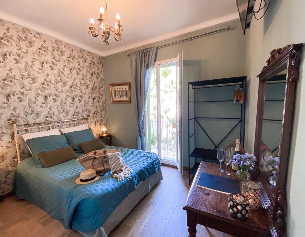 a bedroom with a bed and a mirror and a table at Hotel Le Ponteil in Antibes