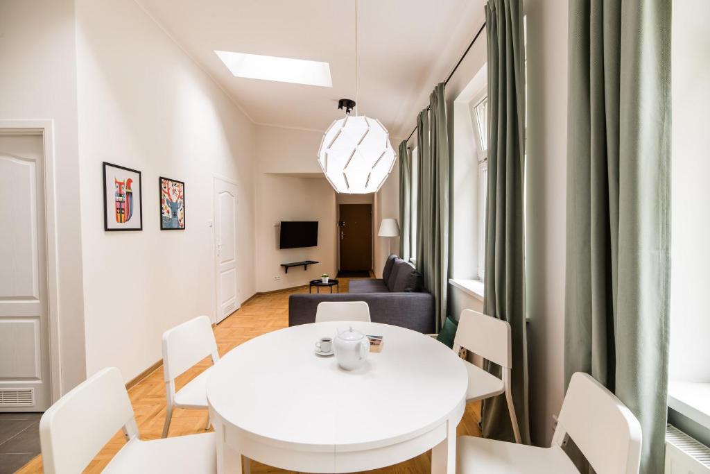 a living room with a white table and chairs at Native Apartments Czysta 5 in Kraków