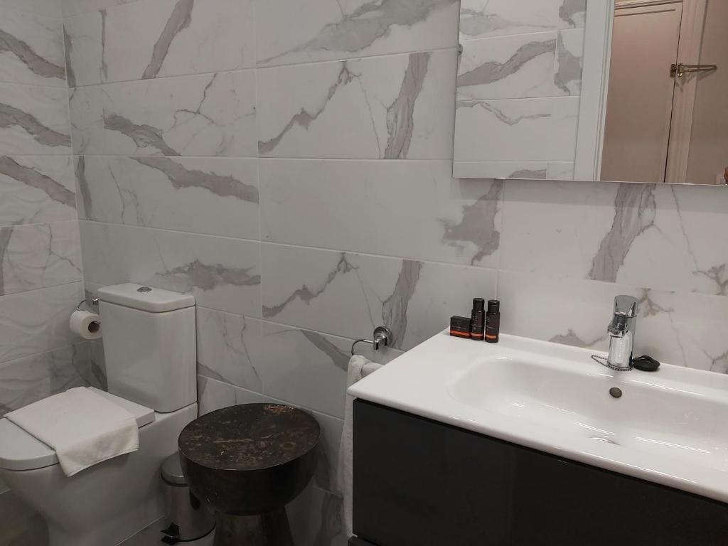 łazienka z umywalką, toaletą i lustrem w obiekcie Del Parque Flats Flores Premium w Maladze