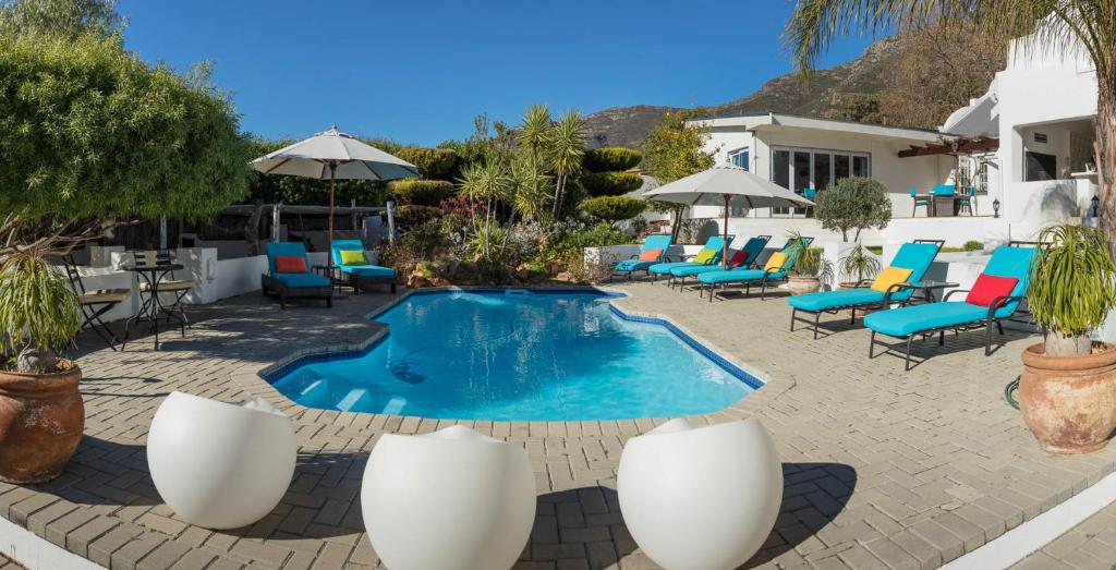 a swimming pool with chairs and a table at Church Hills Boutique Accommodation in Riebeek-Wes