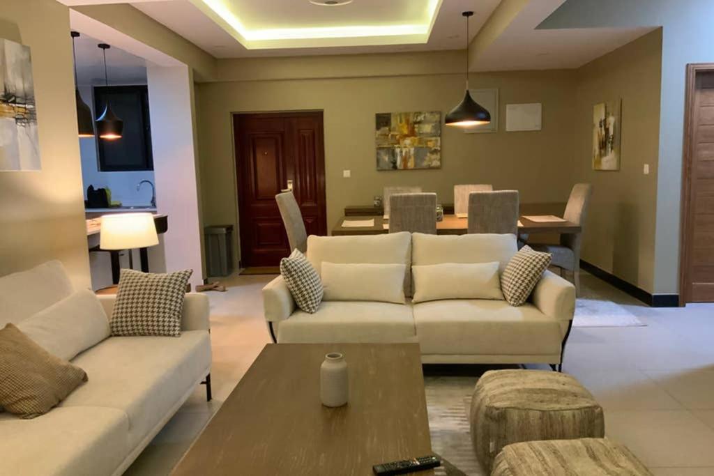 Grany Apartment - Palm Village في دار السلام: غرفة معيشة مع كنبتين وطاولة