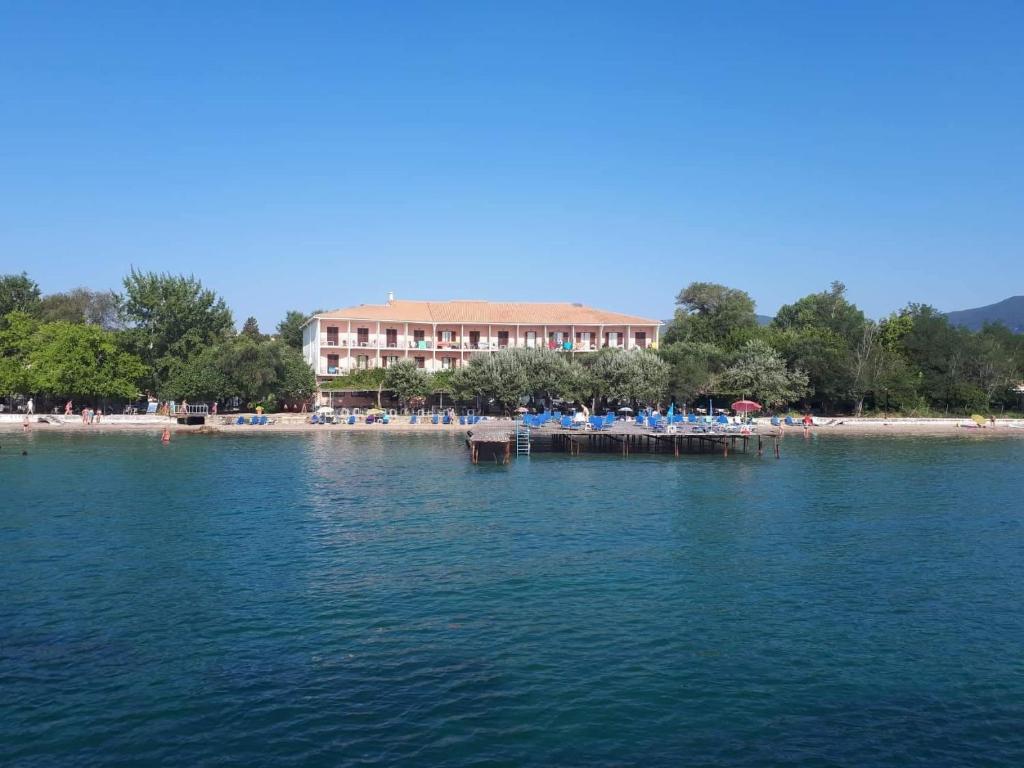 ein Gebäude am Strand mit Stühlen am Wasser in der Unterkunft Dassia Beach Hotel in Dassia