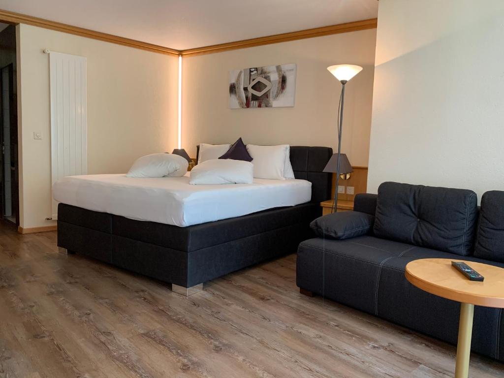 Postel nebo postele na pokoji v ubytování Hotel Quellenhof Leukerbad