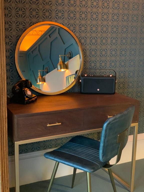 a mirror on top of a dresser with a chair at No.26 By The Sea in Oban