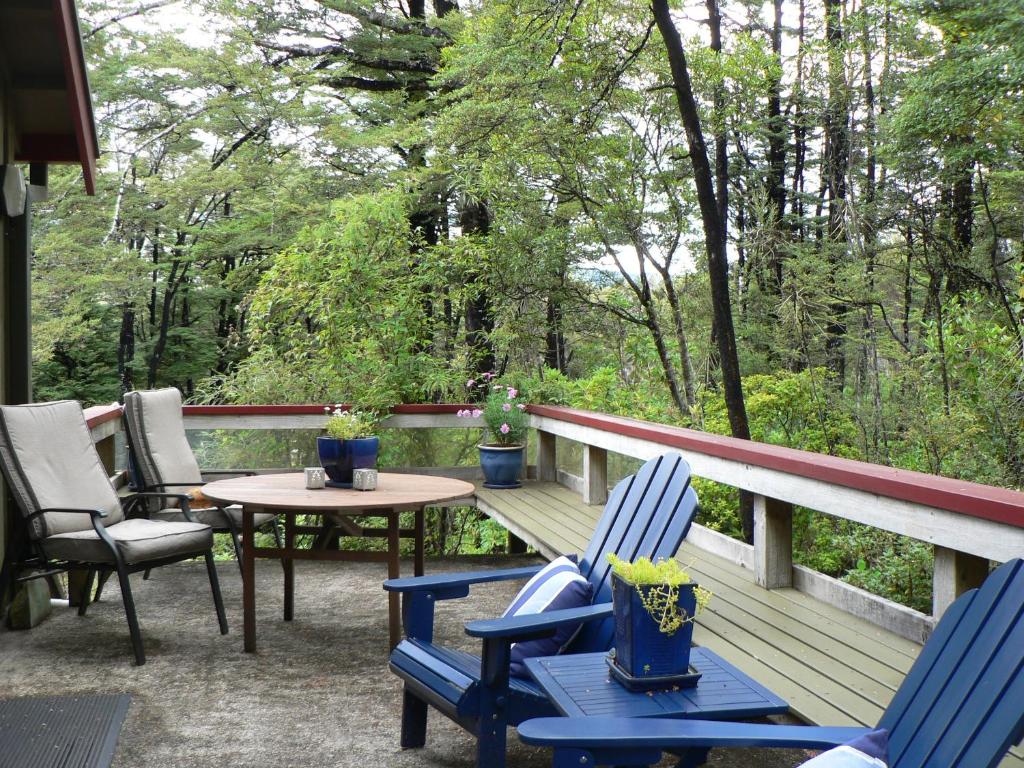 a deck with blue chairs and a table and a table at Avarest Bed & Breakfast in Saint Arnaud