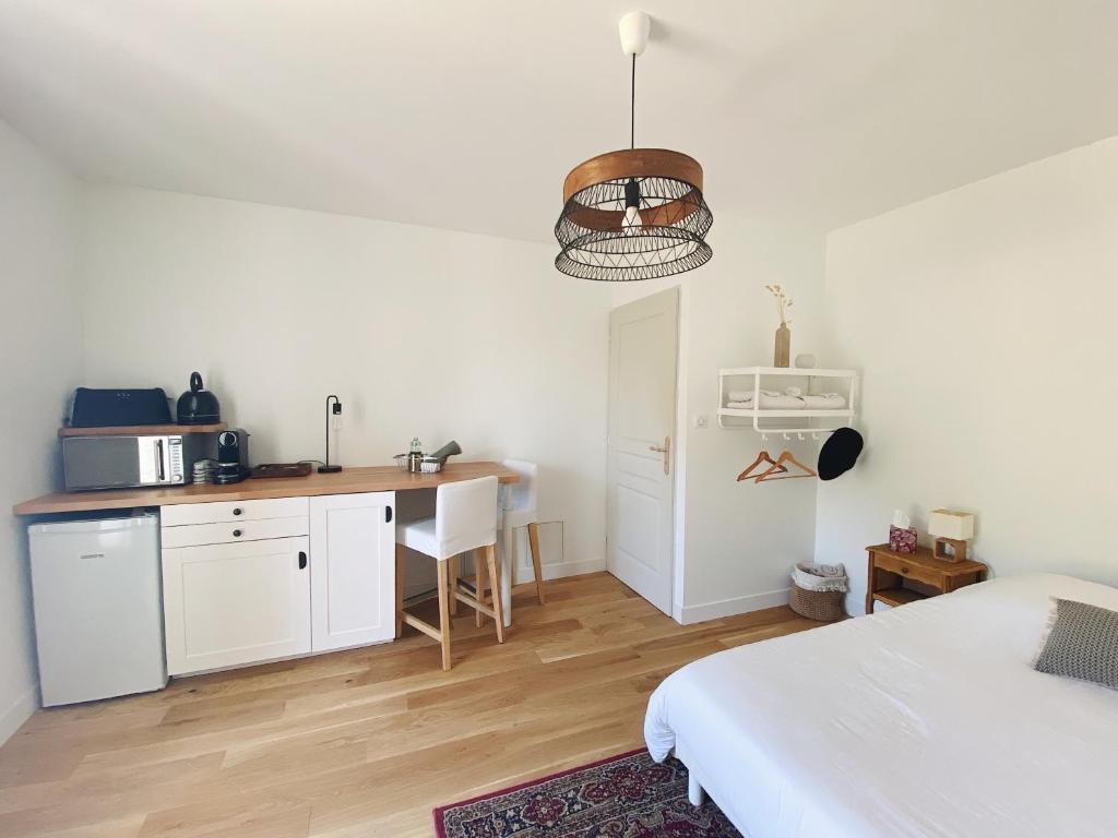 um quarto com uma cama e uma cozinha com uma secretária em L'anne xe, studio indépendant em Valeuil