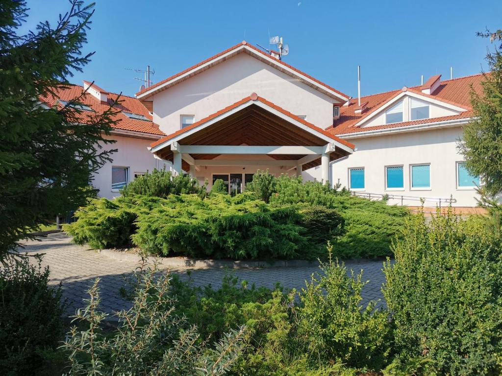 una casa con muchos arbustos delante de ella en Golf Hotel Lisia Polana en Pomocnia