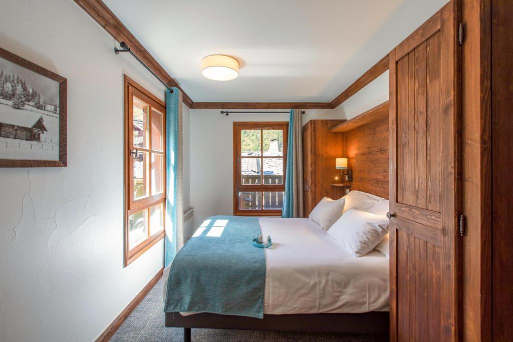 a bedroom with a bed with a wooden door at Résidence Pierre & Vacances Premium Arc 1950 Le Village in Arc 1950