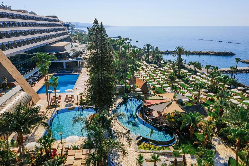 an aerial view of a resort with a pool and the ocean at Amathus Beach Hotel Limassol in Limassol