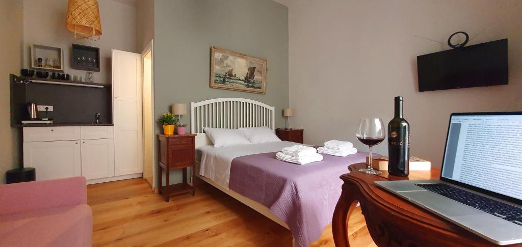 a bedroom with a bed and a desk with a laptop at Muziqa Apartments in Dubrovnik