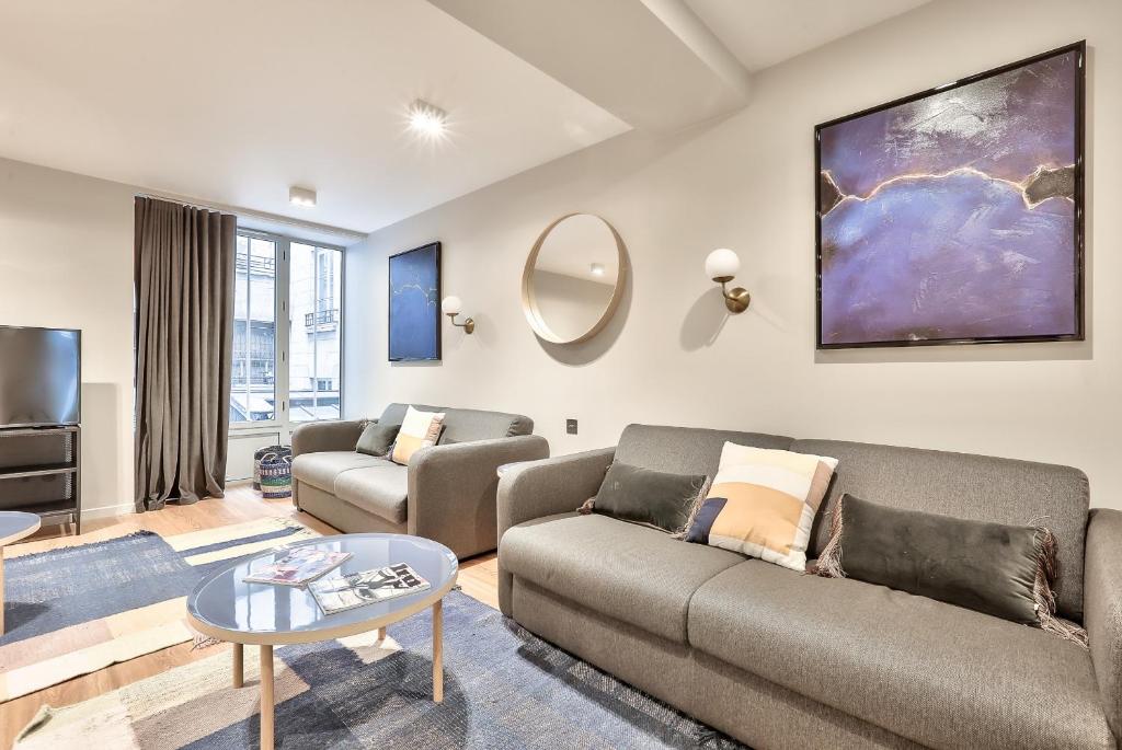 un salon avec deux canapés et une télévision dans l'établissement 121 - Urban Gorgeous Flat in Montorgueil, à Paris