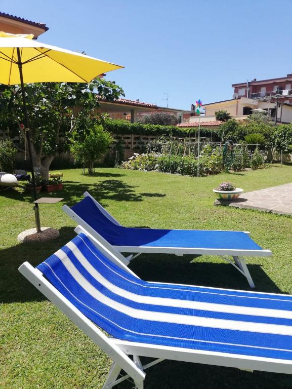 niebiesko-biały fotel i parasol w obiekcie A casa di Iole w mieście Fiumicino