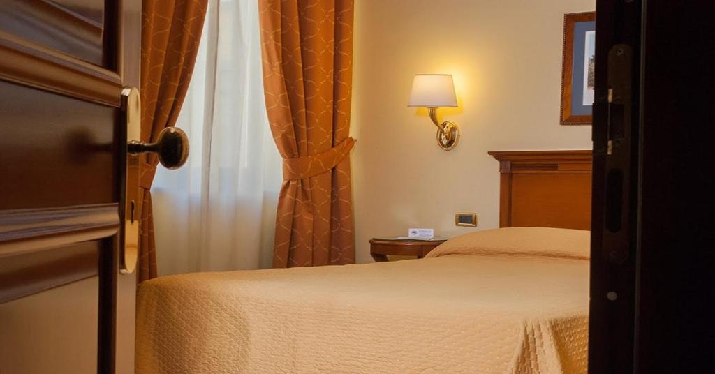 Postel nebo postele na pokoji v ubytování Le Cheminée Business Hotel Napoli