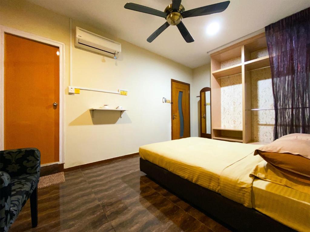 a bedroom with a bed and a ceiling fan at SPOT ON 89858 Rebecca's Homes in Kota Kinabalu