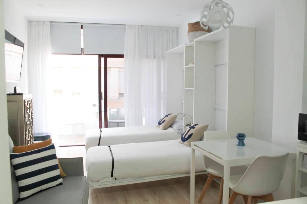 a living room with two beds and a table at VV Loft Canteras Gran Playa "by henrypole home" in Las Palmas de Gran Canaria
