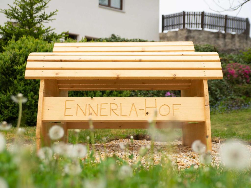 een houten bankje met de woorden 'nood heet' erop geschreven bij Ennerla Hof in Pottenstein