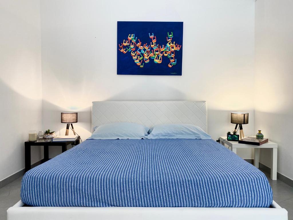 een slaapkamer met een blauw en wit bed met 2 lampen bij Corso Vittorio Giuliano Family in Palermo