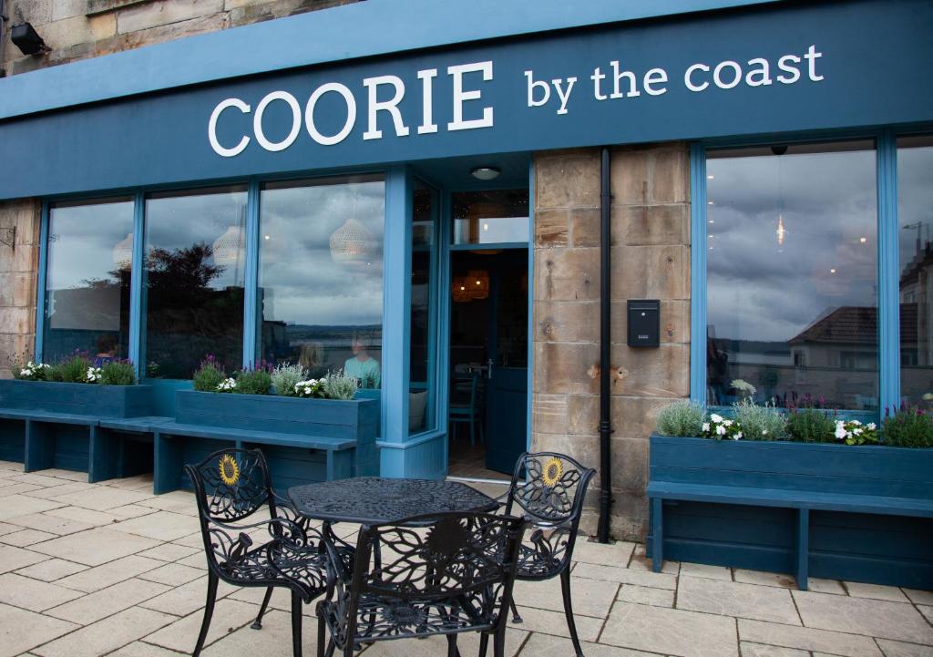 a patio area with a patio table and chairs at Coorie in Dunfermline