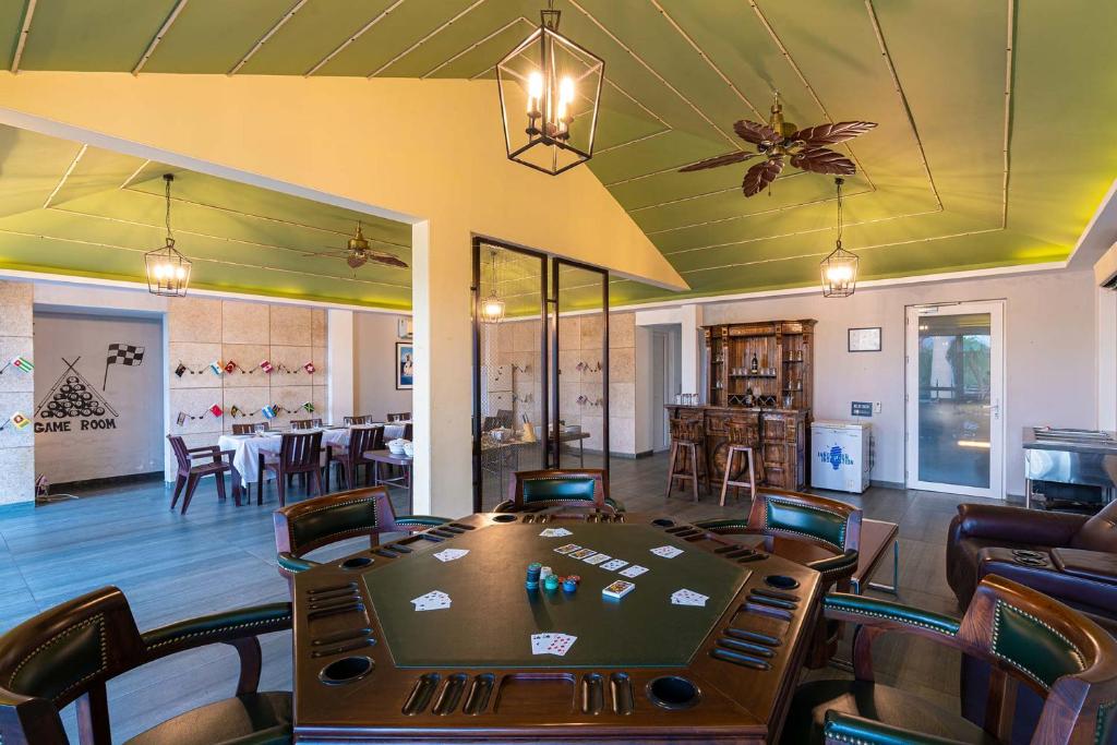 uma sala de póquer com mesa e cadeiras e uma sala de jantar em Baag E Fursat - Luxurious 10BR Villa with infinity swimming pool em Kūrāli