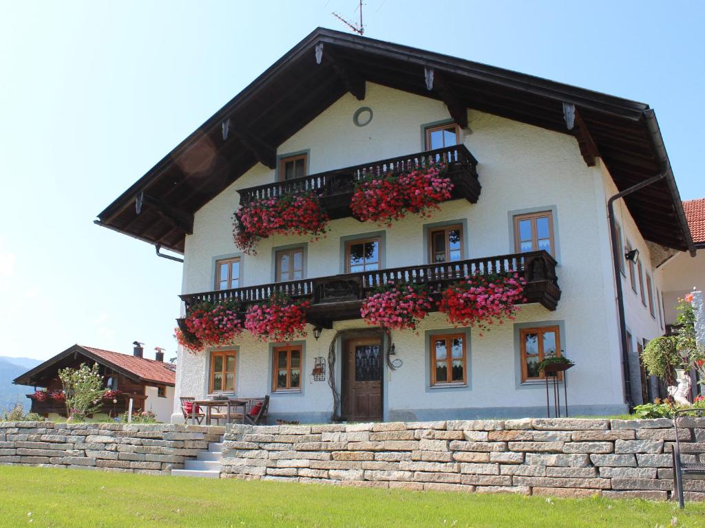 a white house with flowers on the front of it at Hochgallinger Hof in Siegsdorf