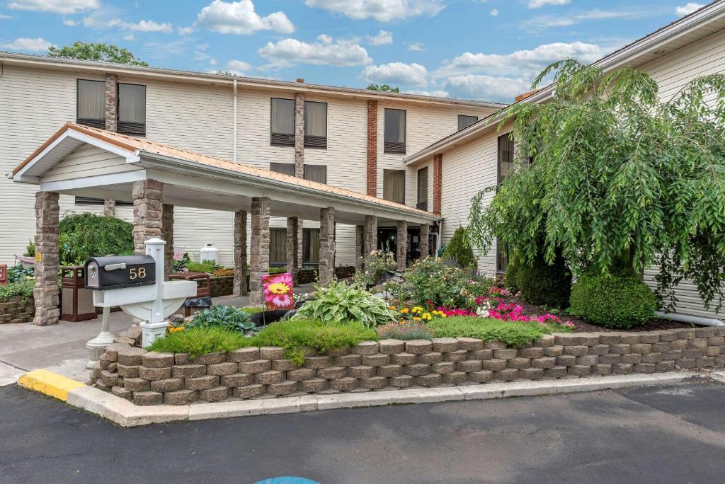 a house with a flower garden in front of it at Comfort Inn in West Hazleton