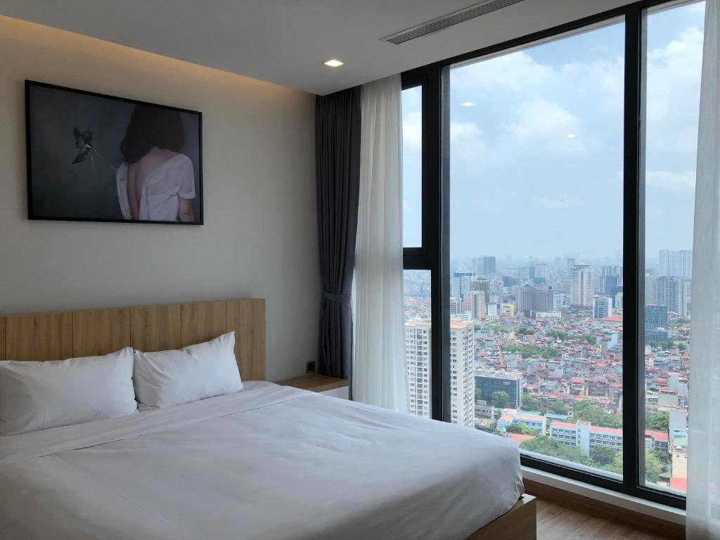 a hotel room with a bed and a large window at Vinhomes Metropolis Luxury Apartment 2 Br in Hanoi
