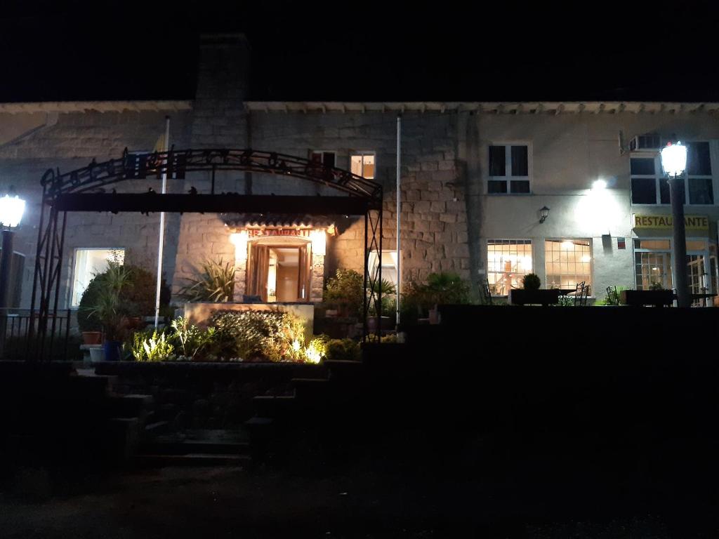 a house at night with lights in front of it at Hotel Sierra Oriente in Guadarrama