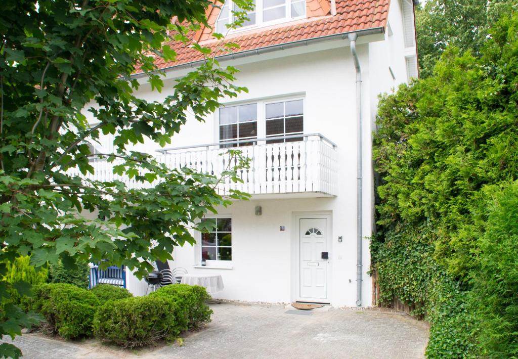 オストゼーバート・ゼリンにあるFerienappartement mit Seeblick und Balkonの白いドアとバルコニー付きの白い家