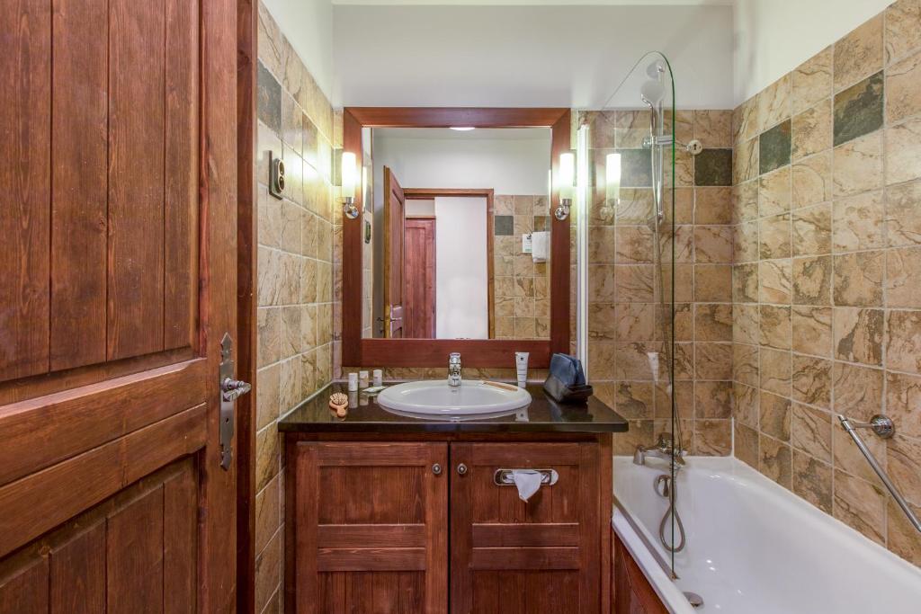a bathroom with a sink and a tub and a shower at Résidence Pierre & Vacances Premium Arc 1950 Le Village in Arc 1950