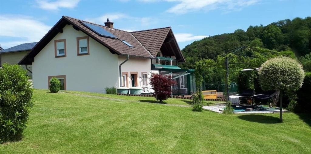 una casa blanca con un patio de césped en Ferienwohnung Auszeit Waxweiler, en Waxweiler