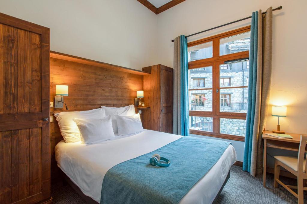 a hotel room with a bed and a window at Résidence Pierre & Vacances Premium Arc 1950 Le Village in Arc 1950