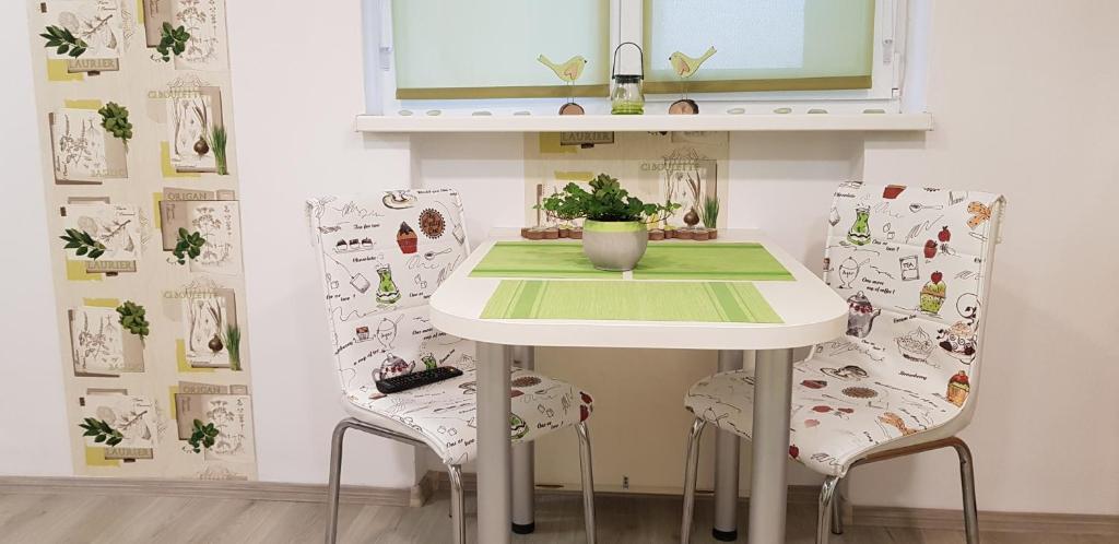 uma mesa e duas cadeiras num quarto com uma mesa em Green Apartman em Târgu-Mureş