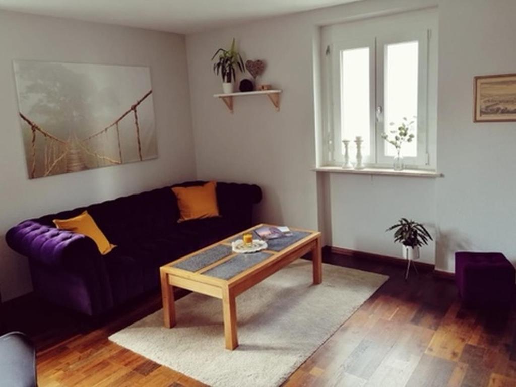 a living room with a purple couch and a coffee table at Ferienwohnung Südschwarzwald in Wehr