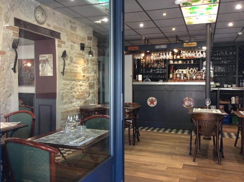 a bar with tables and chairs in a restaurant at Le Richelieu Bacchus in Fontainebleau