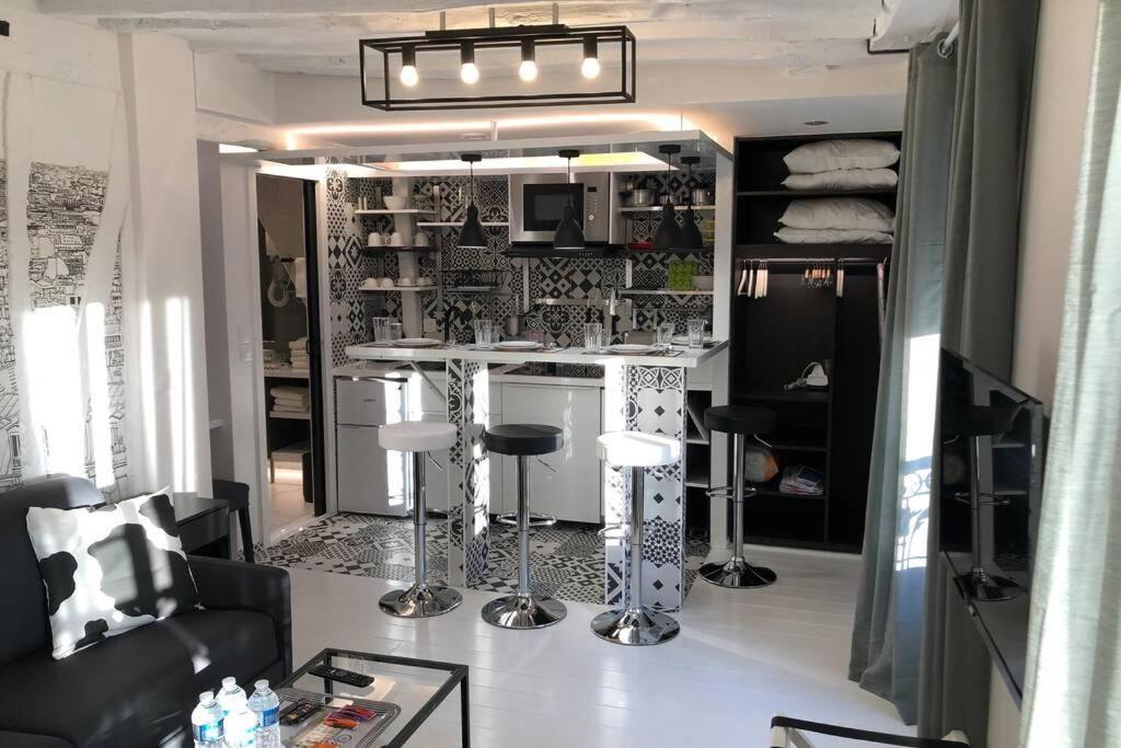 d'un salon avec une cuisine dotée d'un bar. dans l'établissement Appartement Rousselet Quartier Bon Marché Paris VIIème, à Paris