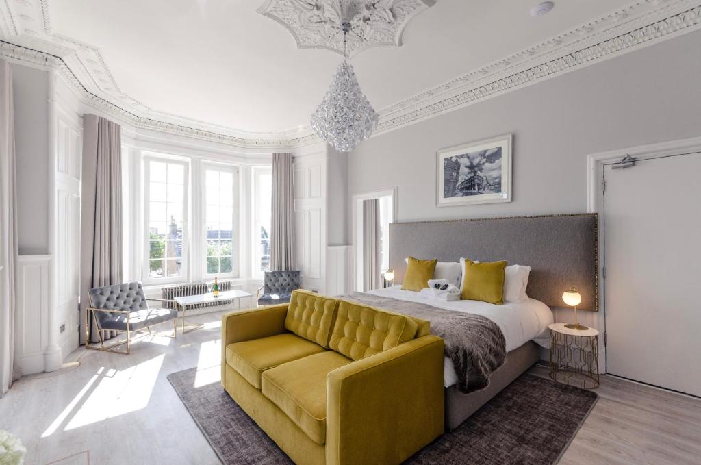 a bedroom with a bed and a yellow couch at Sweeney Apartments & Rooms in Motherwell