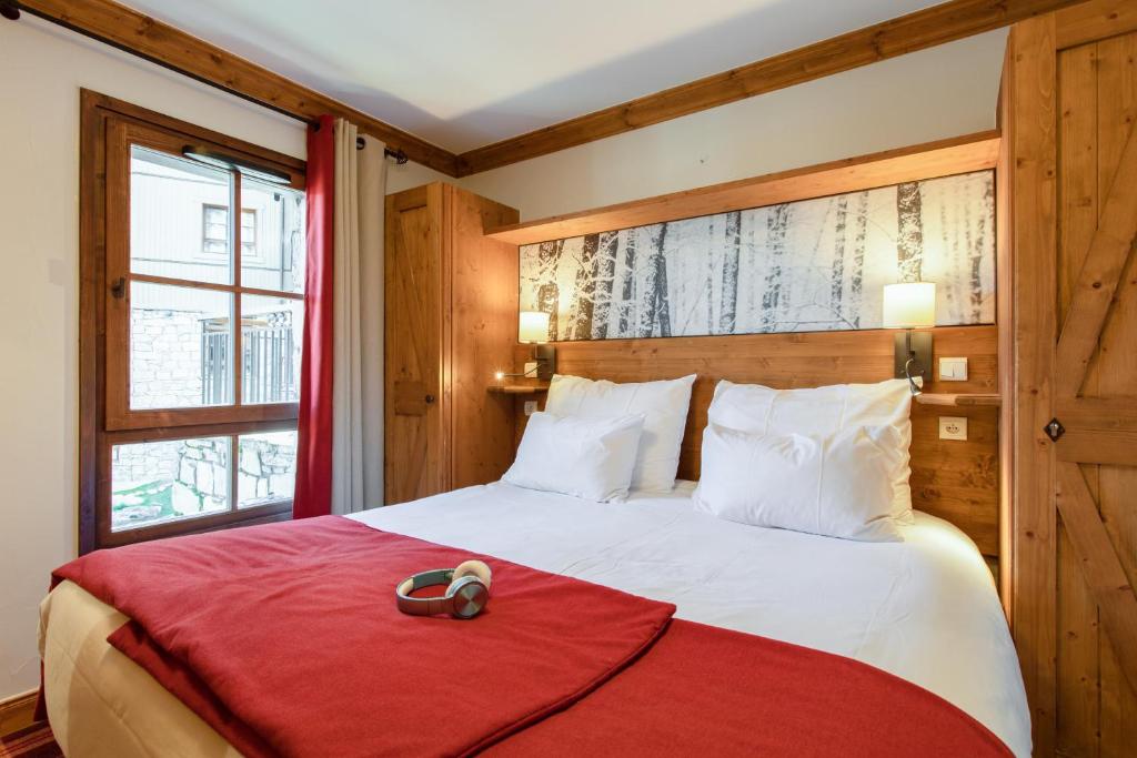 a bedroom with a bed with a red blanket at Résidence Pierre & Vacances Premium Arc 1950 Le Village in Arc 1950